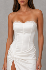 White strapless dress with lace detail on a gray background