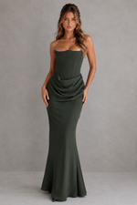 Woman wearing a strapless green gown against a gray background