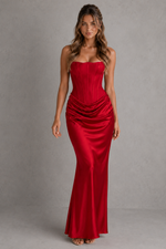 Woman wearing a red strapless gown against a gray background