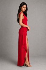 Woman wearing a red dress with a slit on a gray background