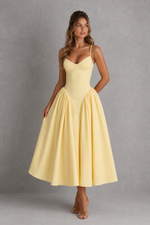 Woman wearing a yellow dress against a gray background