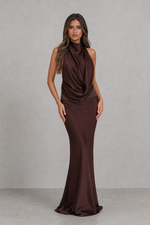Woman wearing a brown evening gown against a plain background
