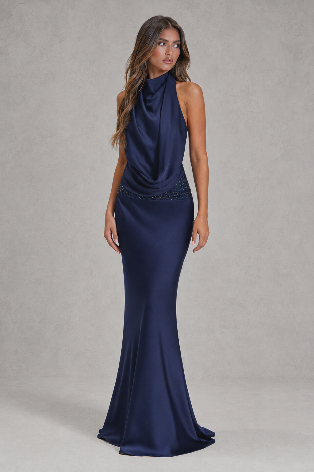 Navy blue evening gown on a model against a neutral background