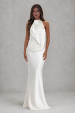 Woman wearing a white evening gown against a gray background