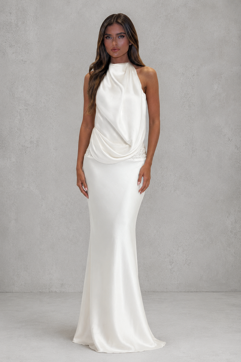 Woman wearing a white evening gown against a gray background