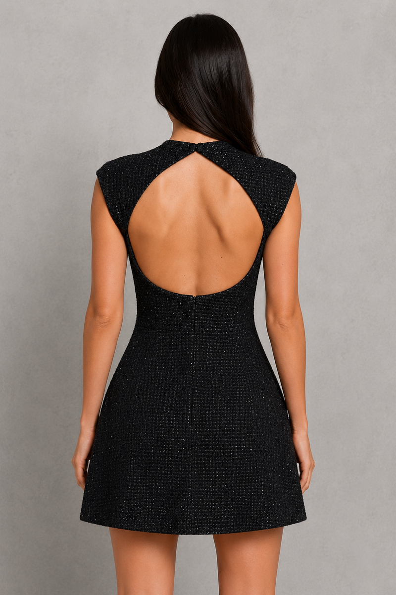 Black dress with open back worn by a model on a gray background