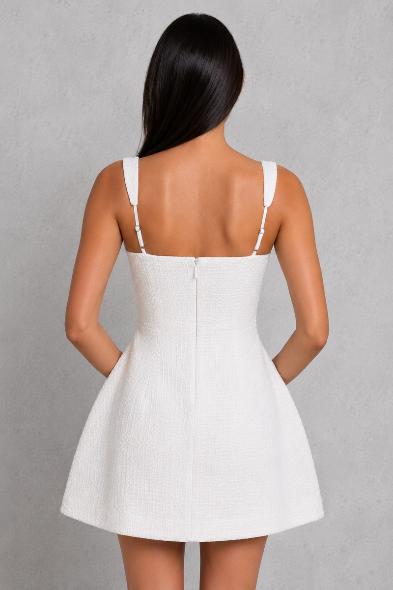 Woman wearing a white dress against a gray background
