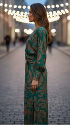 Woman wearing a green patterned dress on a blurred street background