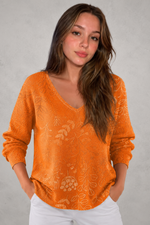 Woman wearing a patterned V-neck top with an autumn-inspired print, featuring a relaxed fit, lightweight breathable fabric, and long sleeves. Styled for casual everyday wear with a flattering feminine silhouette, suitable for pairing with jeans, trousers, skirts, or leggings.