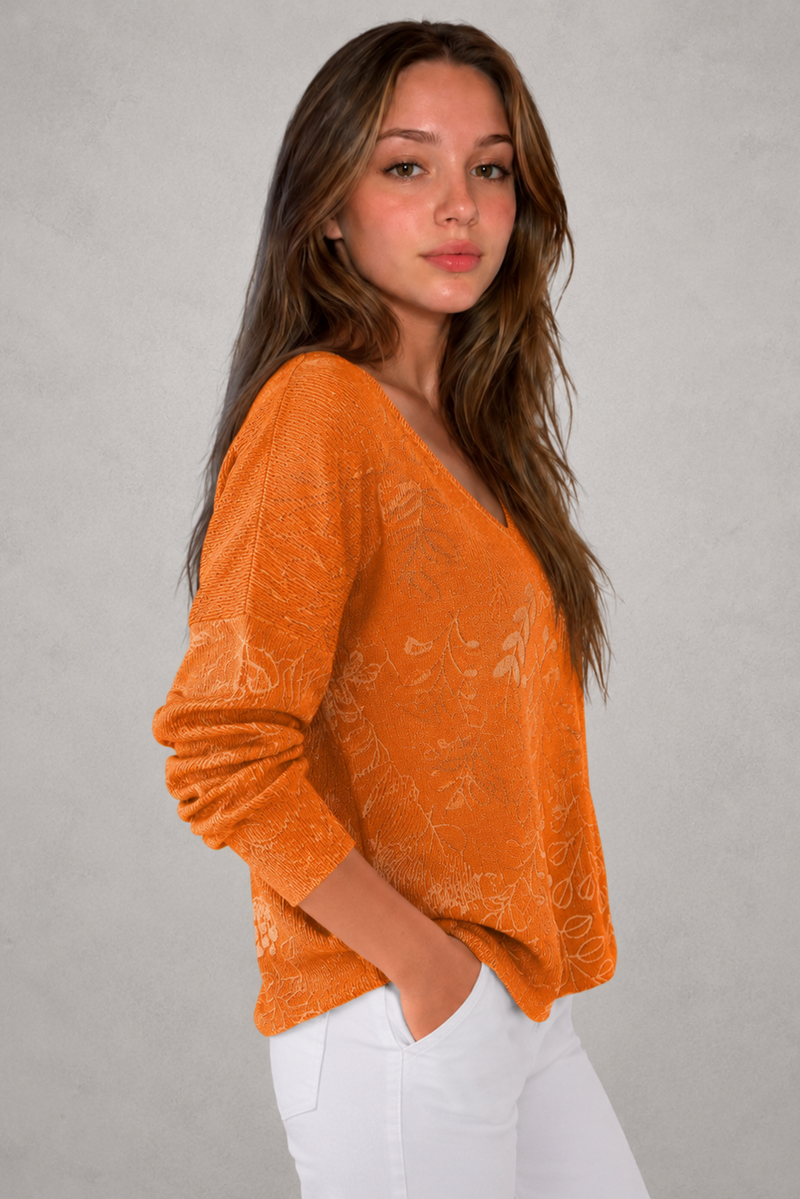 Woman wearing a patterned V-neck top with an autumn-inspired print, featuring a relaxed fit, lightweight breathable fabric, and long sleeves. Styled for casual everyday wear with a flattering feminine silhouette, suitable for pairing with jeans, trousers, skirts, or leggings.