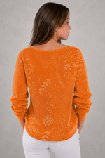 Woman wearing a patterned V-neck top with an autumn-inspired print, featuring a relaxed fit, lightweight breathable fabric, and long sleeves. Styled for casual everyday wear with a flattering feminine silhouette, suitable for pairing with jeans, trousers, skirts, or leggings.