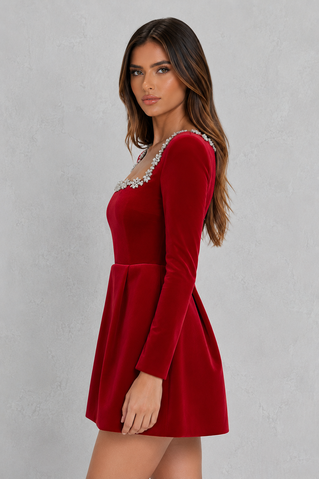 Red dress with long sleeves and embellishments on a gray background