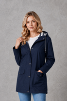 Women's waterproof and windproof hooded coat in a lightweight longline design with adjustable hood, weather-resistant fabric and a flattering regular fit, ideal for everyday wear, commuting and rainy British weather.