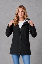 Women's waterproof and windproof hooded coat in a lightweight longline design with adjustable hood, weather-resistant fabric and a flattering regular fit, ideal for everyday wear, commuting and rainy British weather.