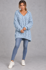 Women's light blue chunky cable knit hooded jumper styled with skinny jeans – full-length front view