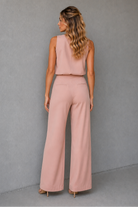 Woman wearing a pink outfit against a gray background
