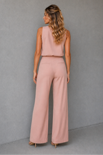 Woman wearing a pink outfit against a gray background