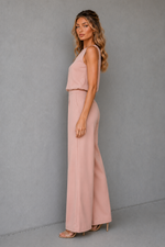 Woman wearing a pink outfit against a gray background