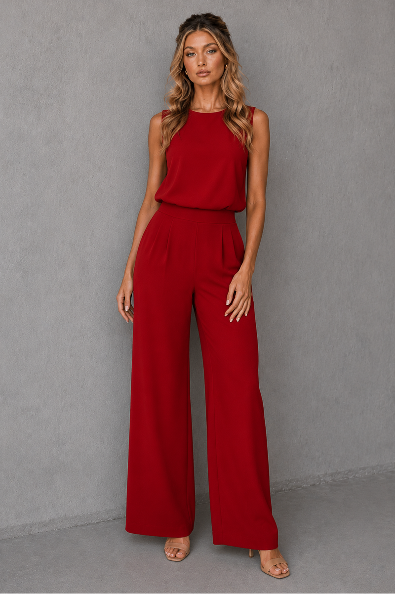 Woman wearing a red jumpsuit against a gray background