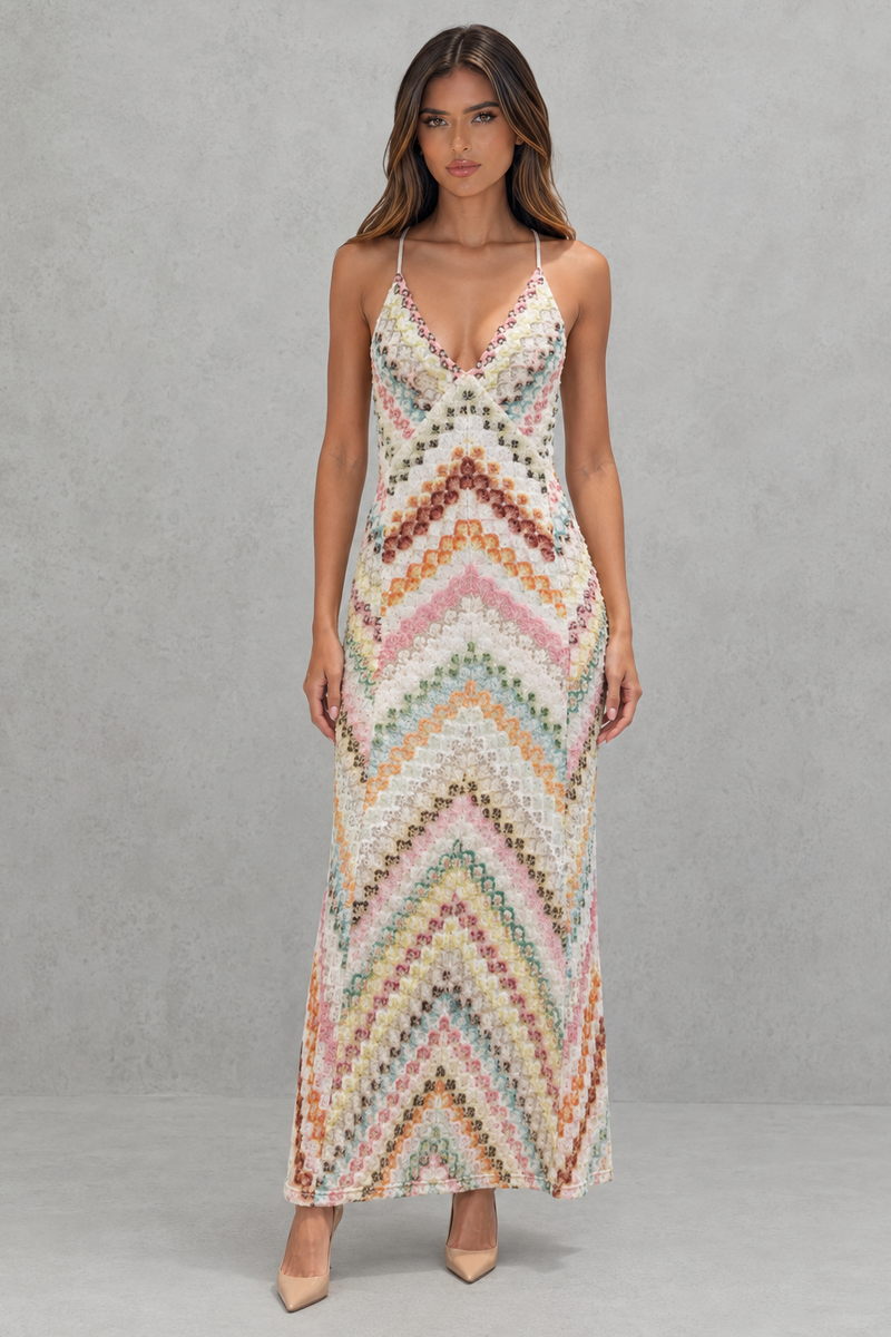 Woman wearing a colorful zigzag patterned dress against a gray background