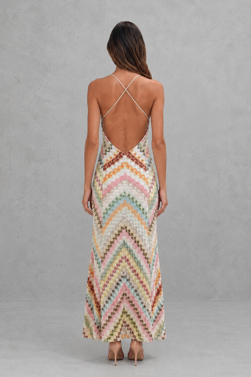 Woman wearing a colorful zigzag patterned dress against a gray background