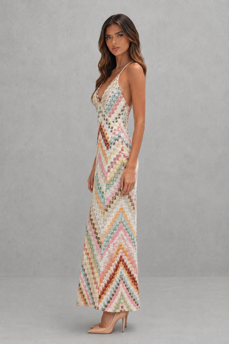 Woman wearing a colorful zigzag patterned dress against a gray background