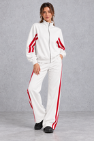 Women's white zip-up tracksuit set with red side stripes – front view
