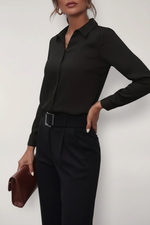 Person wearing a black shirt with a belt against a white background