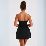 Woman wearing a black strapless dress on a white background