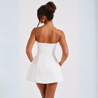 Woman wearing a white strapless dress on a light gray background