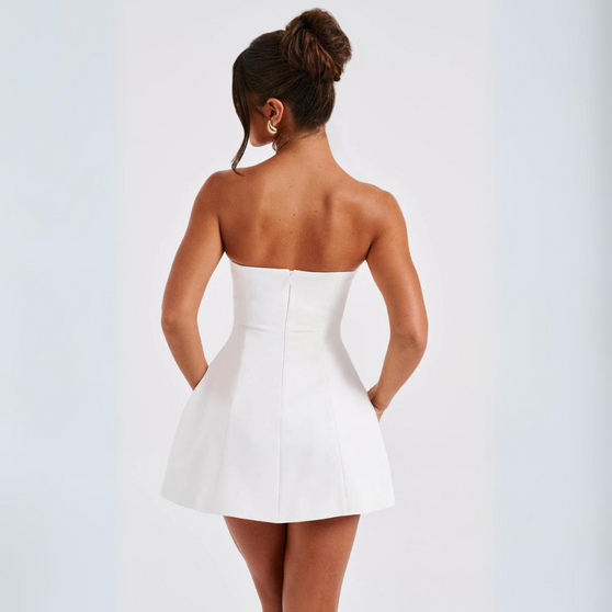 Woman wearing a white strapless dress on a light gray background