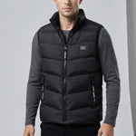 Man wearing a black puffer vest over a gray shirt on a light gray background1