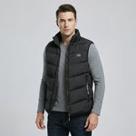 Man wearing a black puffer vest over a gray shirt on a light gray background2