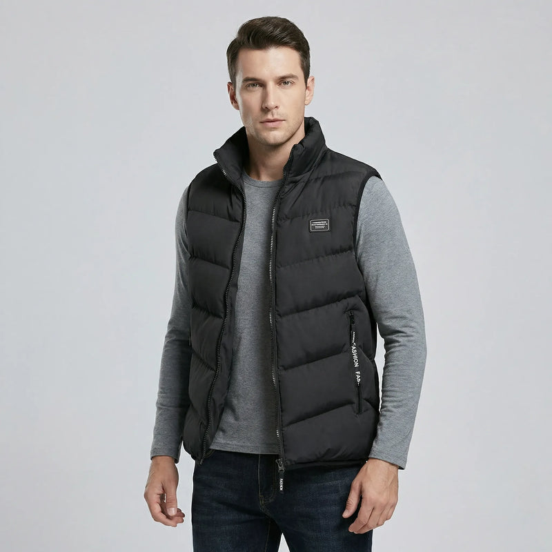 Man wearing a black puffer vest over a gray shirt on a light gray background2