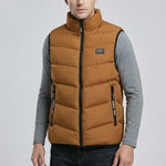 Man wearing a brown puffer vest over a gray shirt on a light gray background