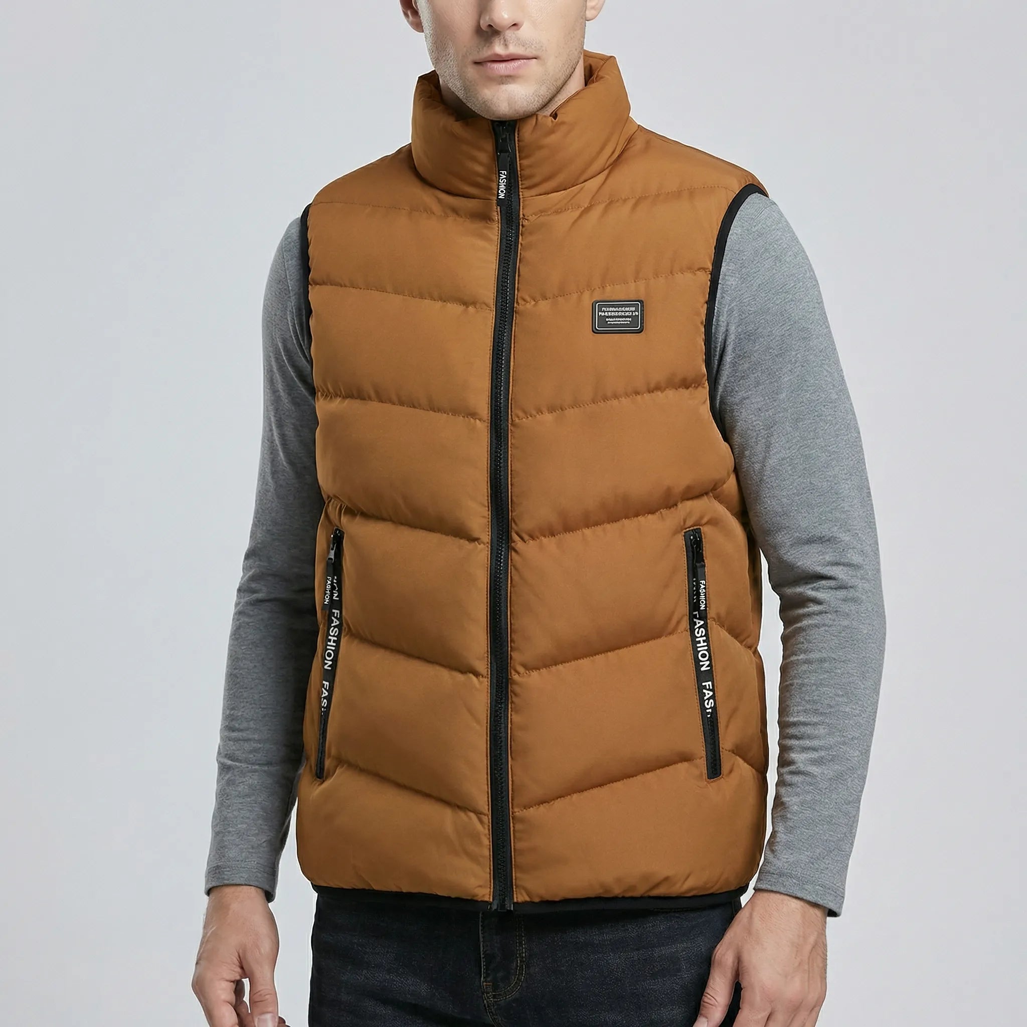 Man wearing a brown puffer vest over a gray shirt on a light gray background