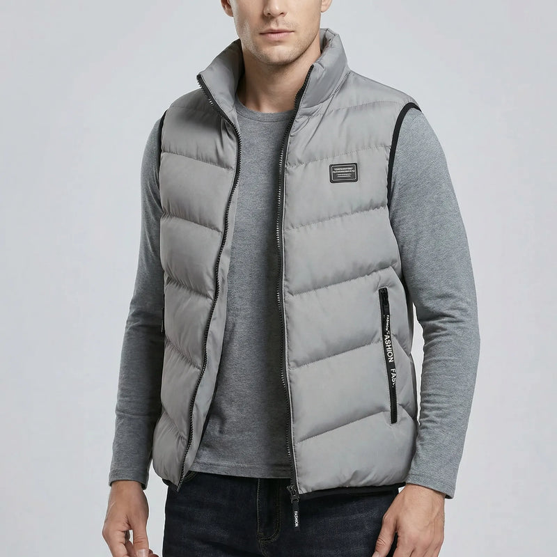 Man wearing a grey puffer vest on a light gray background