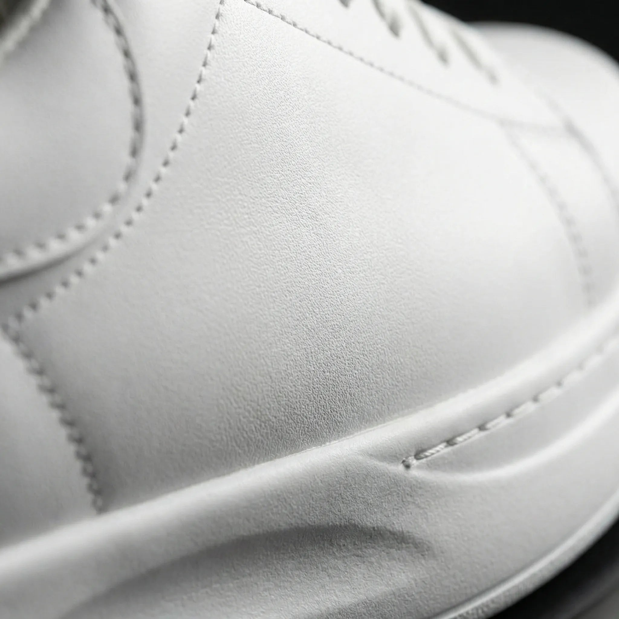 Close-up of a white leather shoe with visible stitching2