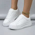 White sneakers worn on a neutral background3