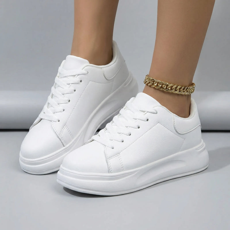 White sneakers worn on a neutral background3