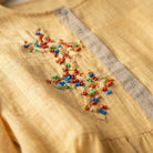 Close-up of a yellow fabric with colorful bead embroidery