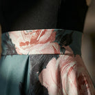 Floral belt with pink and green colors worn on a black garment.2