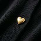 Gold heart-shaped object on a black textured surface