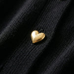Gold heart-shaped object on a black textured surface