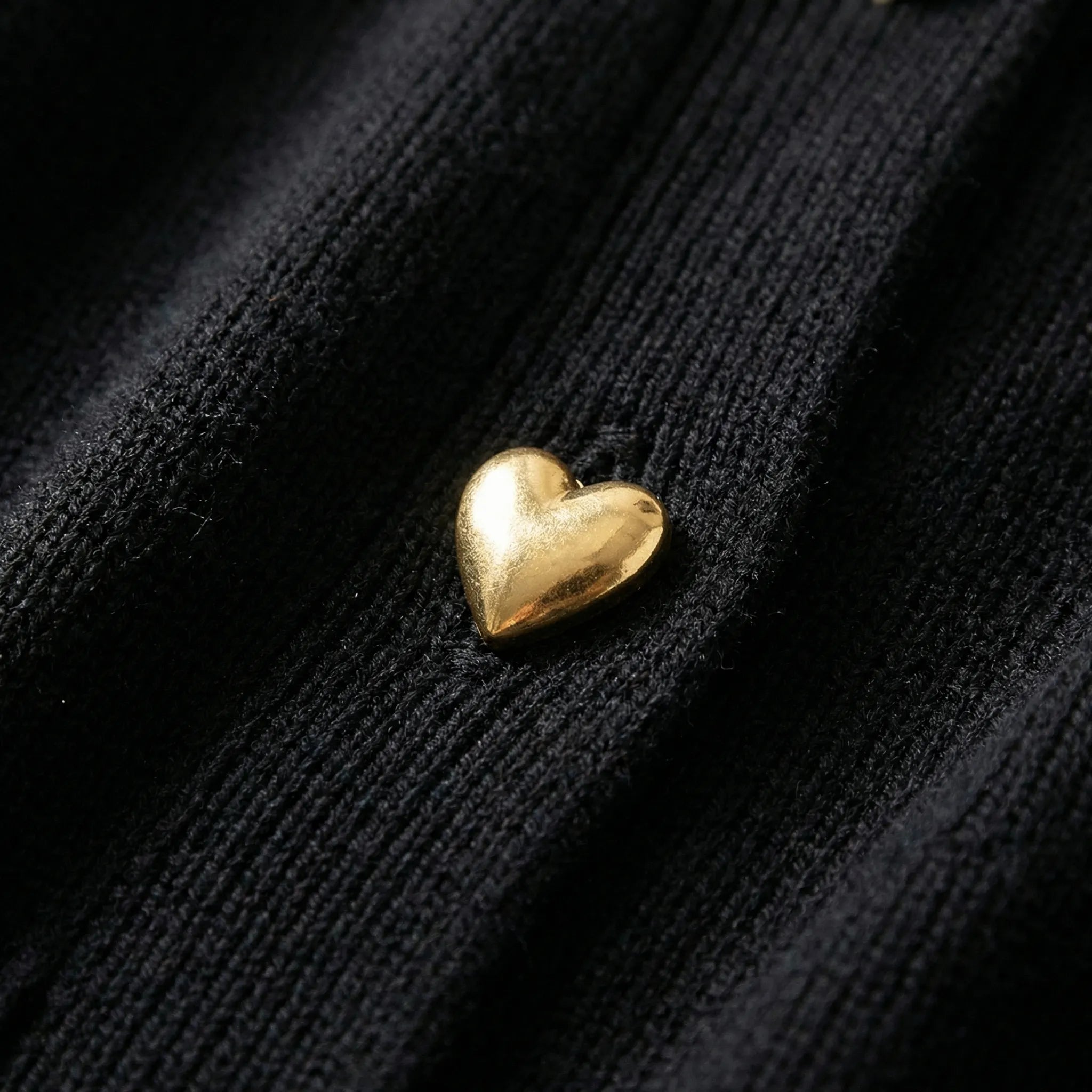 Gold heart-shaped object on a black textured surface