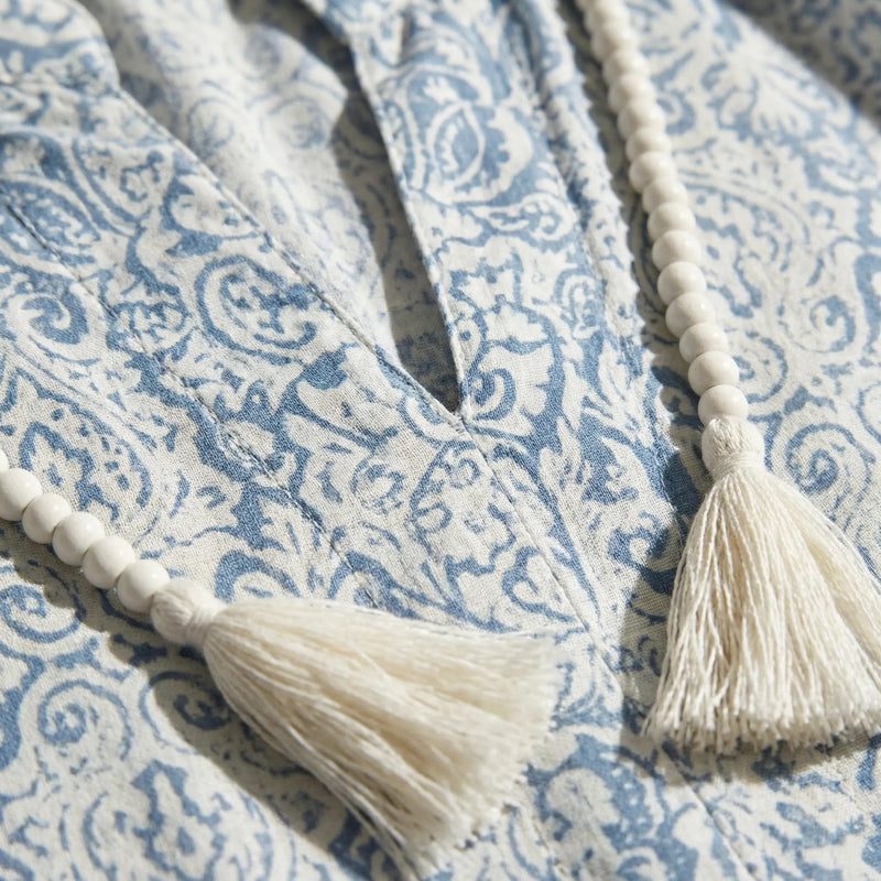 Close-up of a blue and white patterned fabric with tassels.2