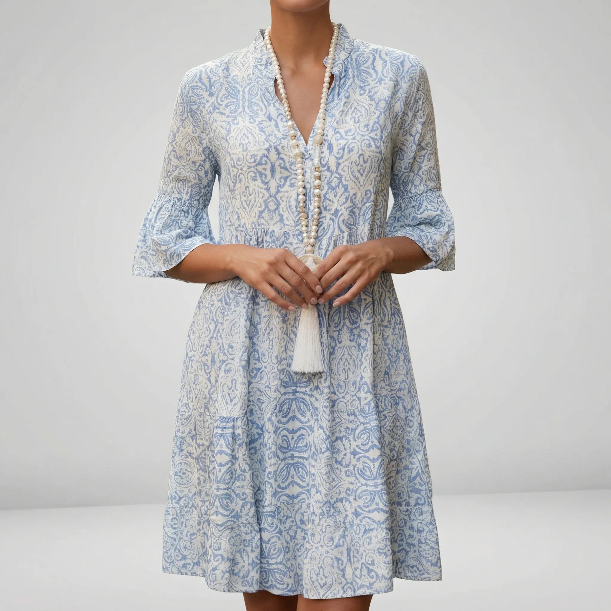 Woman wearing a blue and white patterned dress with a plain background4