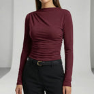 Maroon long-sleeve top worn by a person on a plain background