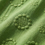 Close-up of green fabric with embroidered patterns2