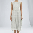 White sleeveless dress with floral patterns on a plain background